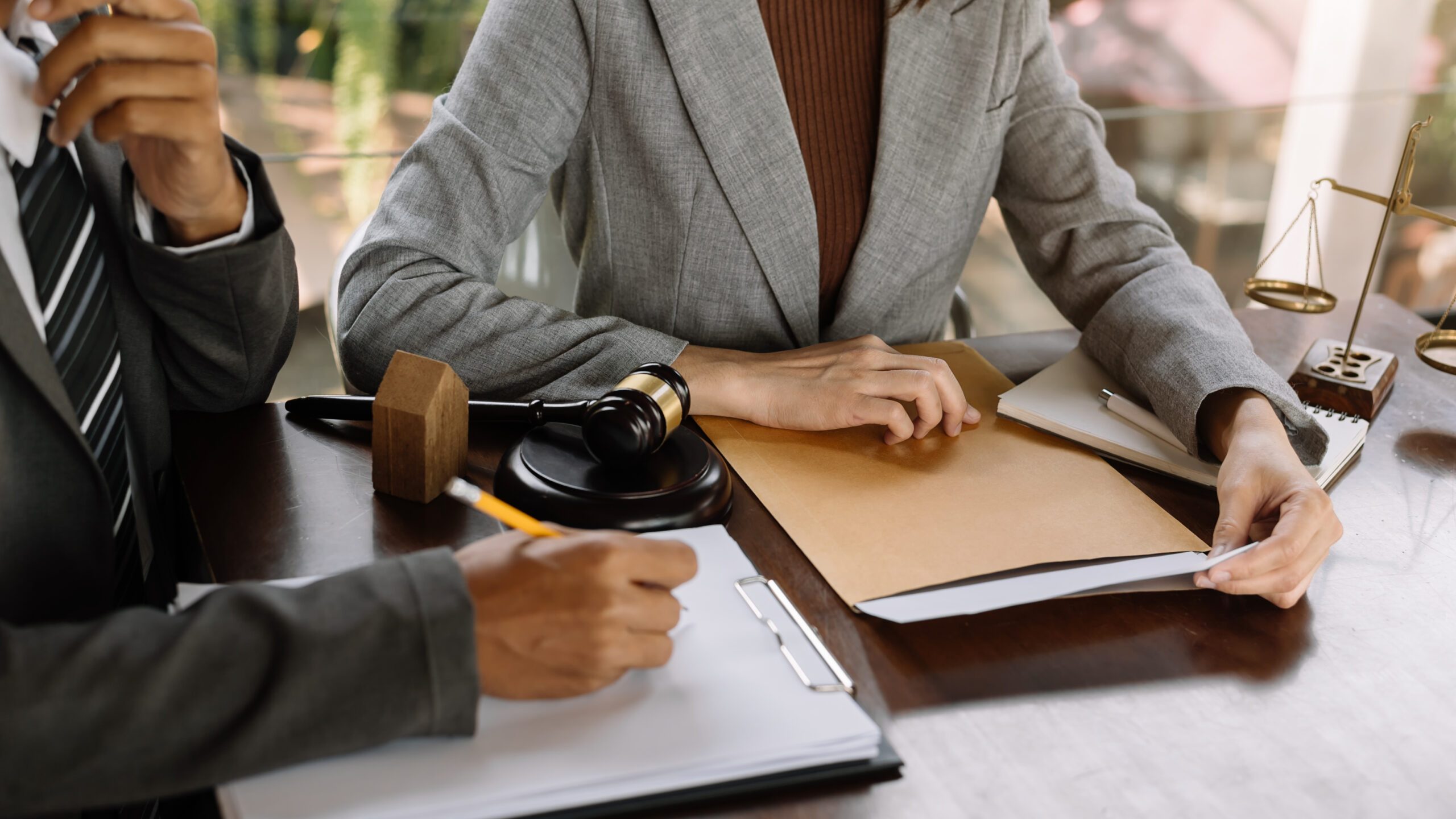 Business and lawyers discussing contract papers with brass scale on desk in office. Law, legal services, advice,  justice and law concept .