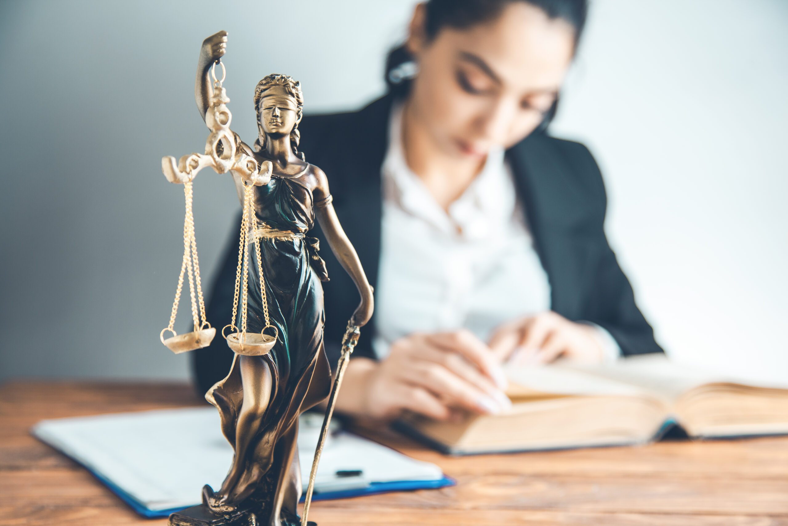 woman hand book with  justice lady on desk